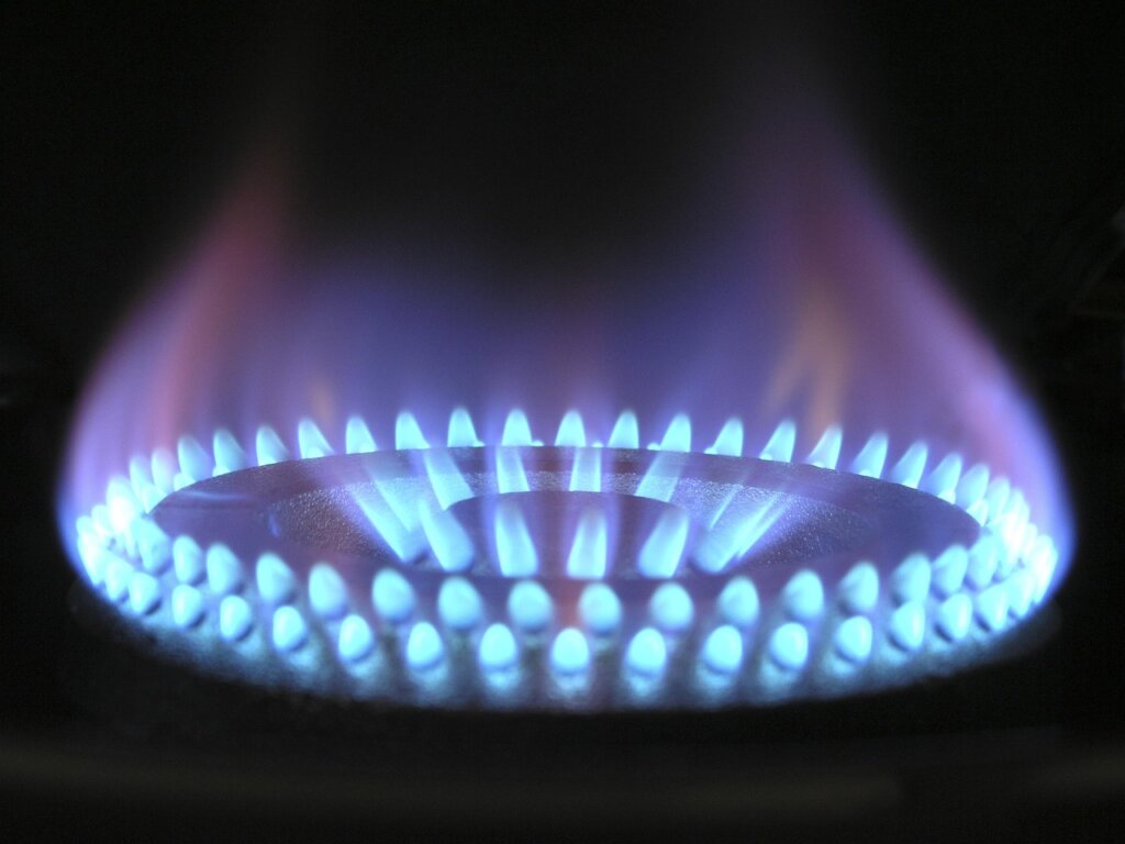 gas stove burner caps soaking in soapy hot water in sink