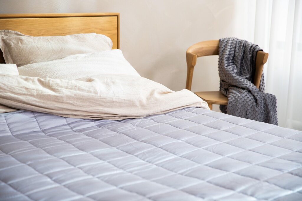 mattress protector cover being put on bed