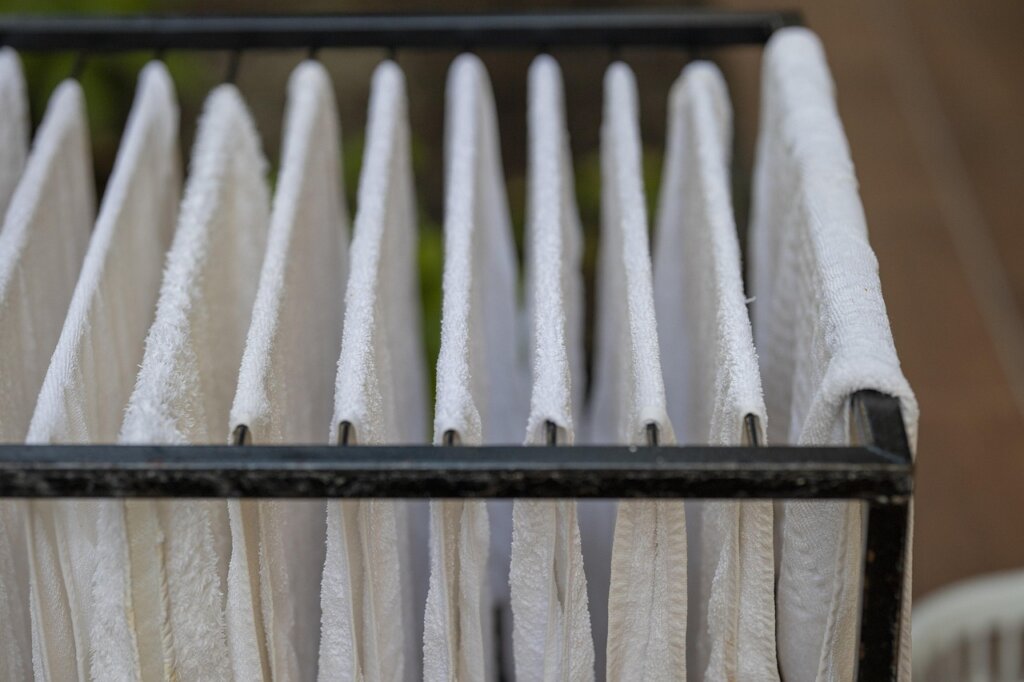 drying bathroom tiles with white towel after cleaning