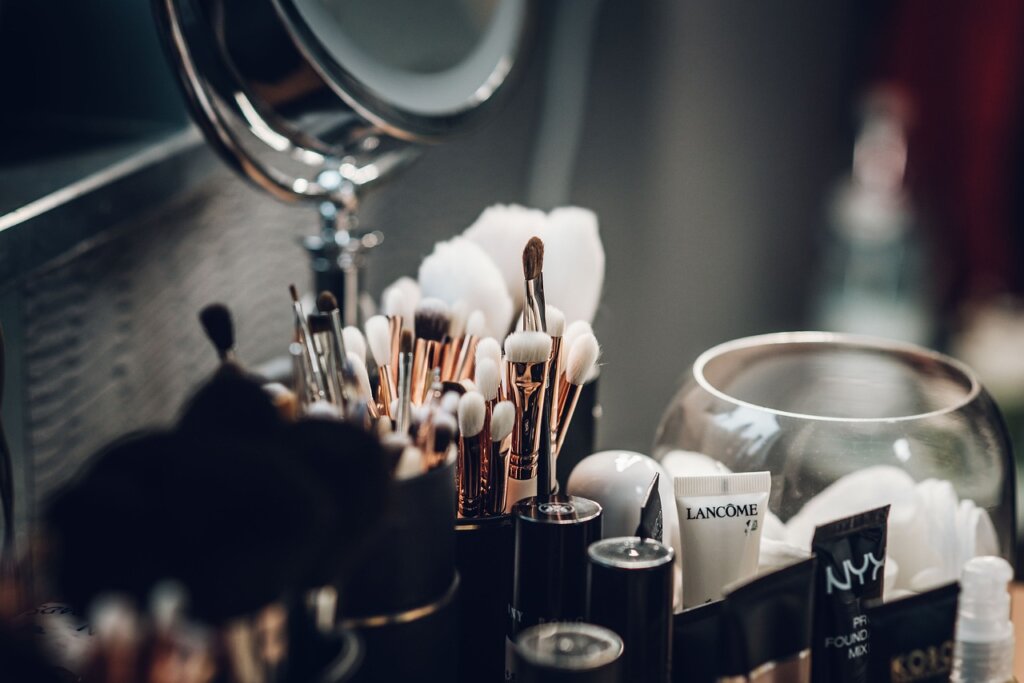 small bottle of citric acid powder placed next to toilet brush on bathroom shelf