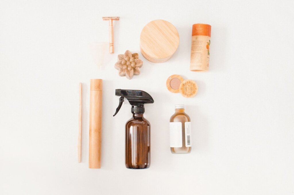 flat lay of cleaning supplies including vacuum cleaner, steam cleaner, baking soda box on white background
