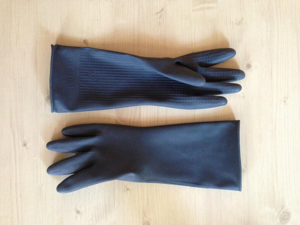 person wearing rubber gloves cleaning kitchen drain mesh filter