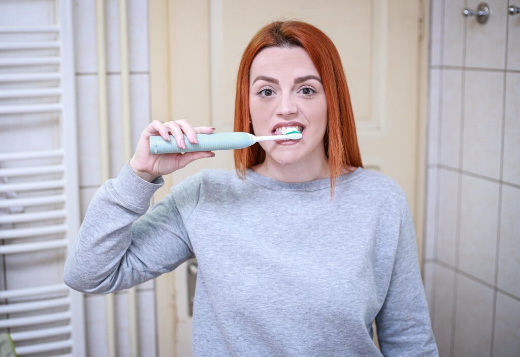 electric cleaning brush spinning on white bathroom floor