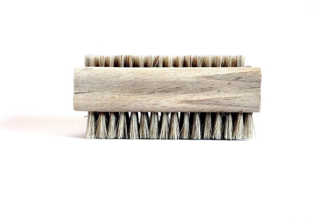 scrubbing bathroom tiles with a small grout brush