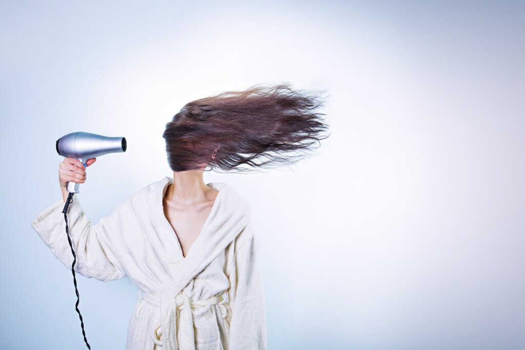 hair dryer blowing warm air onto freezer frost